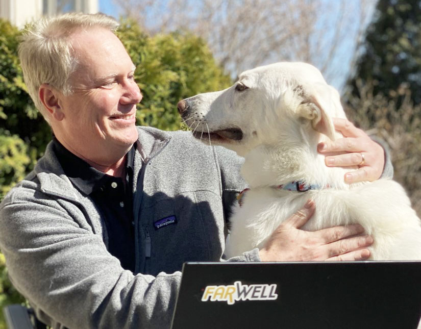 Bob Fanning outside with his dog and a laptop